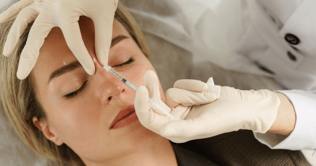 A women getting injectables in her forehead at a dermatology clinic.